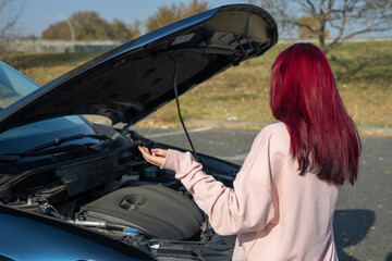 The female driver's car broke down, the hood of the car is open.