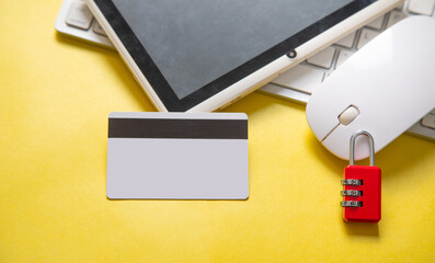 Padlock, credit card, computer keyboard on the yellow background.