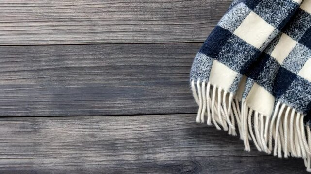 Soft wool scarf featuring a classic navy and cream check design placed on a rustic wooden table, perfect for autumn styling