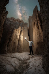 Obraz premium Man inside a Moon Cave under the milky way galaxy at Cathedral Gorge State Park in Nevada 