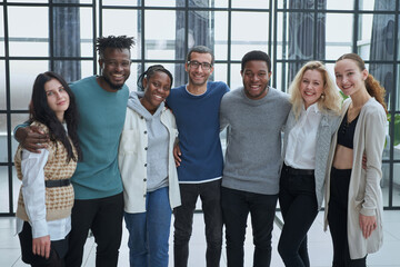 Happy diverse professional business team stand in office looking at camera,