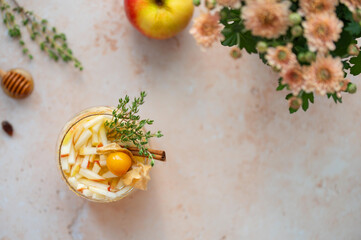 Apple cider bourbon fall cocktail with cinnamon, thyme, honey and physalis for single serving. Close up. Autumnal drink. Top view