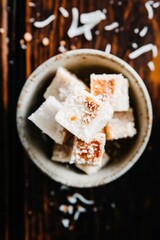 Rustic ceramic dish filled with homemade amaranth bars and coconut flakes