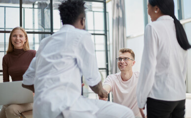 Obraz premium Happy friendly multiracial team laughing working together at corporate briefing