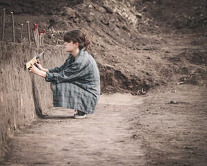 An archaeologist measures the stratigraphy of a cultural layer (field archaeological work)