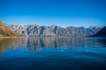 Bay of Kotor in Montenegro and the top of high snow-capped mountains, small settlements on the...