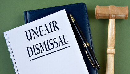 UNFAIR DISMISSAL - words on a white sheet with a judge's gavel