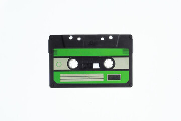 A vintage audio cassette tape with an green and black label, isolated on a white background, evokes nostalgia and retro vibes.