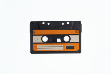 A vintage audio cassette tape with an orange and black label, isolated on a white background, evokes nostalgia and retro vibes.