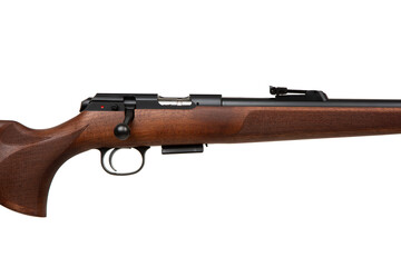 A .22lr caliber rifle with a wooden stock and black barrel, featuring a bolt-action mechanism and...