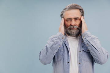Fototapeta premium Senior man suffering from headache touching temples with hands