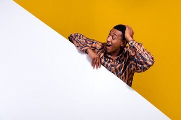Joyful young man in a stylish print shirt excitedly interacting against a vivid yellow background