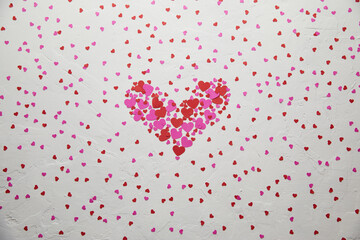 Heart-Shaped Arrangement of Red and Pink Hearts on Textured White Background