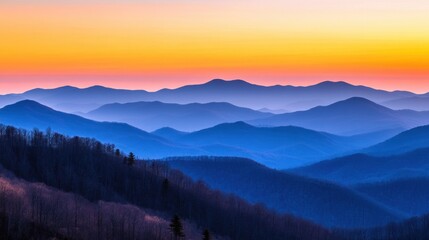 Fototapeta premium Mountain landscape with layers of peaks fading into the horizon under an orange sky