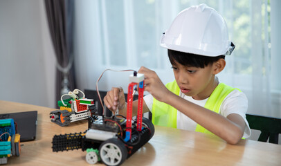Young boy working on a robot design in Robotics programming class. STEM education using constructor blocks and laptop, Technology educational development for school kids