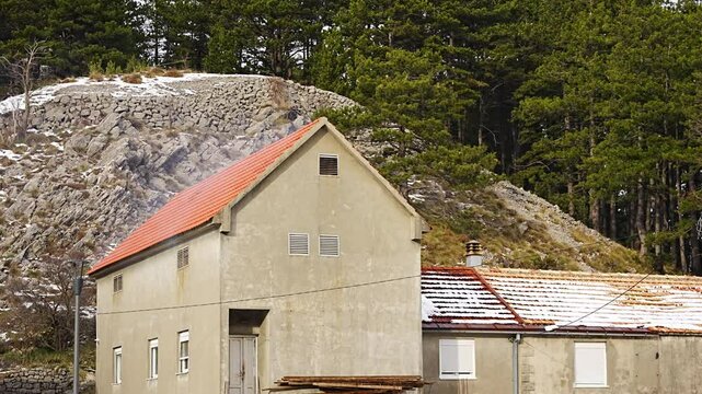 Smoke coming from a smokehouse located under the roof of a house in traditional village Njegusi in Montenegro in winter time