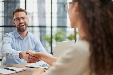 Obraz premium Young business people shaking hands in the office. Finishing successful meeting.