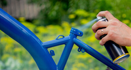Spray Painting a Bicycle Frame Outdoors © Anna