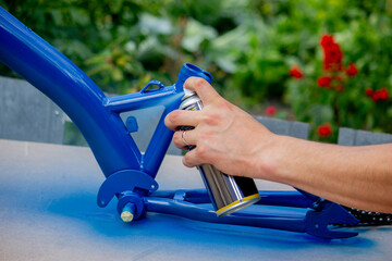 Spray Painting a Bicycle Frame Outdoors © Anna