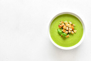Spinach soup with croutons in white bowl