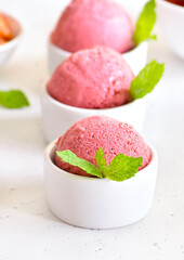 Strawberry ice cream scoop in white bowl