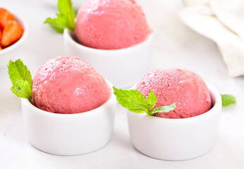 Strawberry ice cream scoop in white bowl