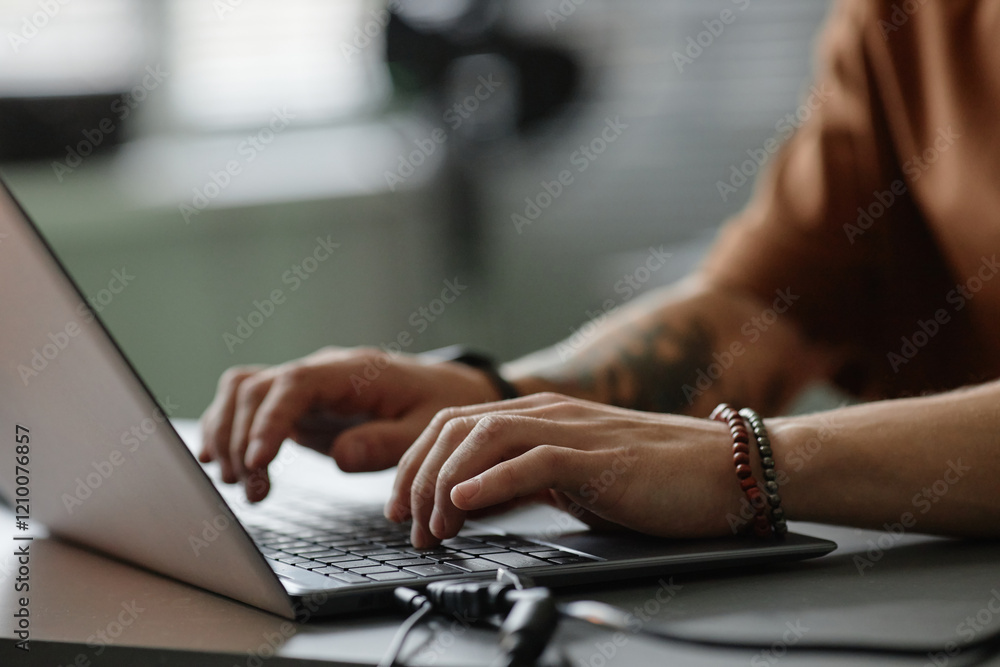 Poster cropped shot of male programmer typing on laptop keyboard coding in office, copy space