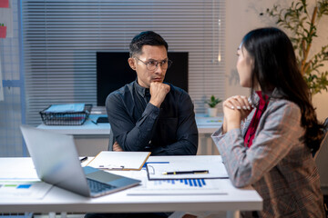 Business people having a serious conversation about work at night in the office