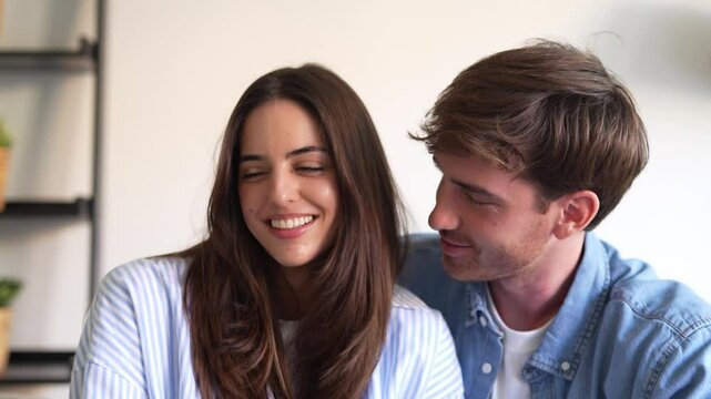 Portrait of young 20s just married couple in love posing photo shooting seated on couch in modern studio apartments, concept of capture happy moment, harmonic relationships, care and sincere feelings
