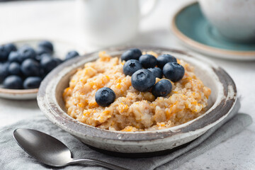 Pumpkin oatmeal porridge with fresh blueberries topping. Healthy fitness menu breakfast meal