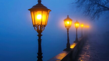 Obraz premium A row of streetlights glowing faintly in the fog.
