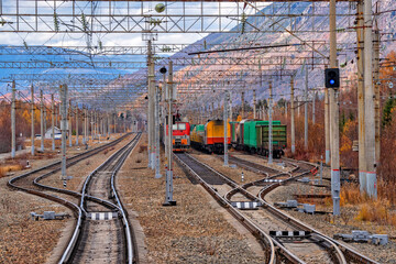 Railway tracks against a beautiful sunset and mountains. Railway Station with trains....