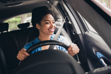 Young African American woman enjoying a drive in the city in daylight
