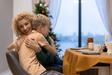 Happy Mother and Son Embracing in a Festive Home Setting During Holidays