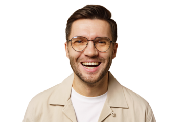 Young man with glasses smiling joyfully in a light-colored jacket against a white background