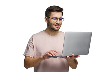 Man wearing glasses smiles while using laptop in a bright indoor setting during daylight hours