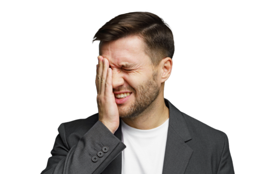 Man in a suit expresses frustration while covering his face with one hand in a studio setting