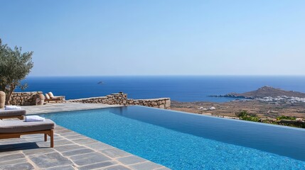 Fototapeta premium Luxury infinity pool overlooking the tranquil blue sea and distant beach with clear sky in a serene coastal setting.