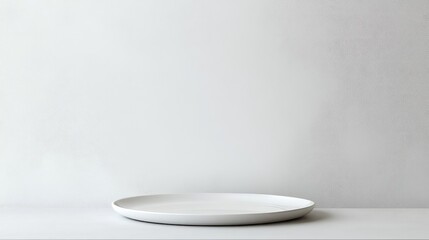 Elegant White Plate on Minimalist Restaurant Table with Neutral Background and Ample Copy Space for Menu or Promotion
