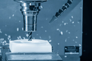 The CNC milling machine cutting the nylon parts with flat nose end mill tool in the light blue...