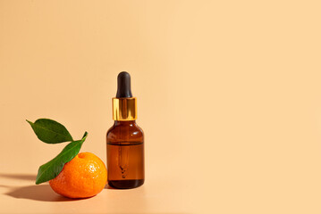 Face serum, essential oil bottle and orange fruit