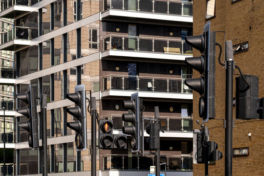 The image features multiple traffic lights illuminated against a backdrop of modern high-rise buildings and glass facades, showcasing urban architecture and city life in London UK