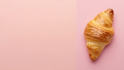 Flaky, golden-brown croissant on pastel pink background