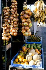 Throughout a Costa Rican farmers market, a colorful array of hanging bananas and onions were strung from the ceiling and draped to add visual appeal and brightness.