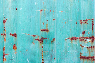 Close-up of rust and scratches on a textured teal surface. Weathering effects and the charm of...