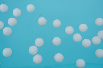 Many of white plastic balls floating on a swimming pool