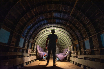 person with torch standing in old plane body at night in the dark