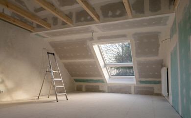 Renovation in a private house. Plastering drywalls in the attic. 
