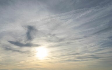 Golden sunset sky with the sun veiled between clouds (cirrus)