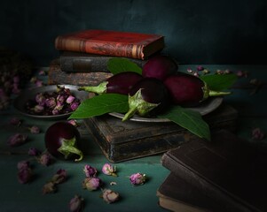 still life with old books, eggplants, rosebuds